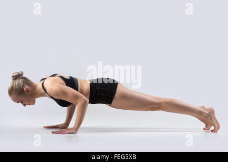 Belle jeune femme sportive pratiquant le yoga, faire chaturanga dandasana (quatre membres constituent le personnel) pour les abdominaux Banque D'Images