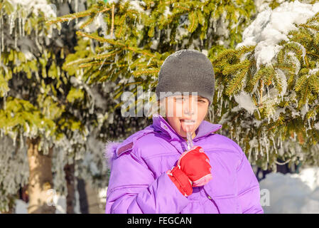 Little girl licking icicle Banque D'Images