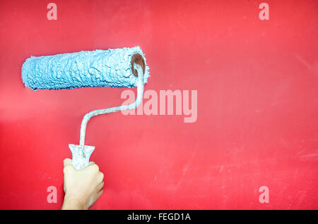 Fillette de huit ans la peinture du mur à la maison Banque D'Images