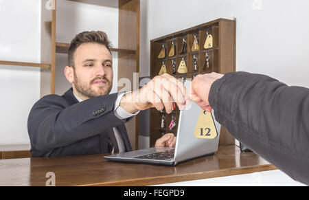 Image d'une personne à son bureau en donnant la clé d'un client. Selective focus sur la clé. Banque D'Images