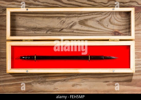 Pinceau calligraphie chinoise en fort sur fond de bois Banque D'Images