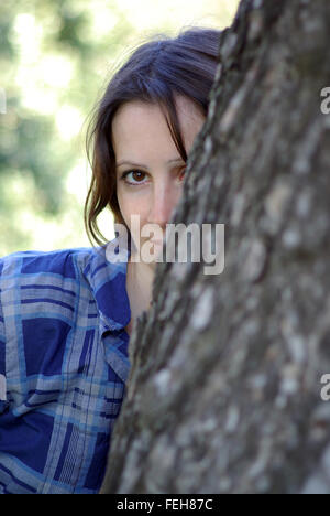 Femme se cache un arbre Banque D'Images