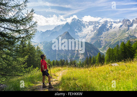 Hiker resting devant le majestueux massif du Mont Blanc (4810 m) et ses glaciers fondants. Aventures d'été dans le Val d'Aoste, Banque D'Images