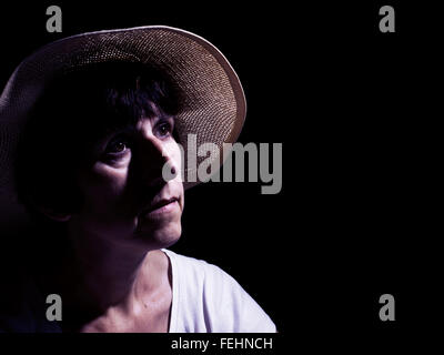 Femme d'âge moyen en chapeau de paille, mélancolique. Image de couleur, filtré. Banque D'Images