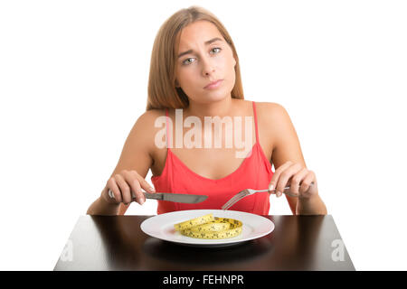 Notion de droit d'une femme sur un régime alimentaire, manger un ruban à mesurer, isolé Banque D'Images