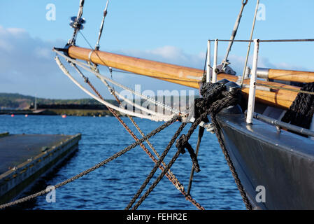 Beaucoup de cordes noir tenir le navire à voile noir. Un point en bois bout dehors en mer avec une partie de la jetée sur le côté visible. Banque D'Images