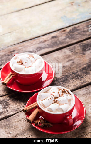 Chocolat chaud avec de la guimauve avec des bâtons de cannelle sur table en bois. Boisson chaude restaurant menu background with copy space Banque D'Images