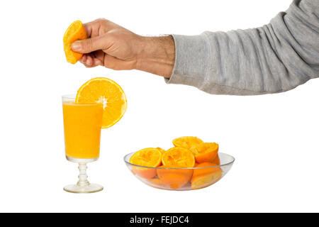 Serre la main en verre de jus d'orange avec des oranges Banque D'Images