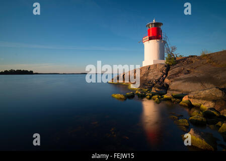 Le phare sur la côte rocheuse de l'île de l'archipel suédois Yxlan dans l'archipel, près de Stockholm, au coucher du soleil Banque D'Images