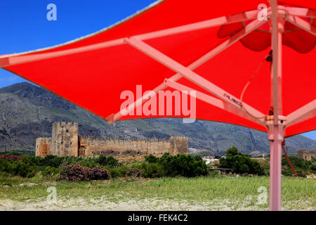 Crète, parasols rouge et la forteresse Frangokastello sur la côte sud de l'île méditerranéenne Banque D'Images