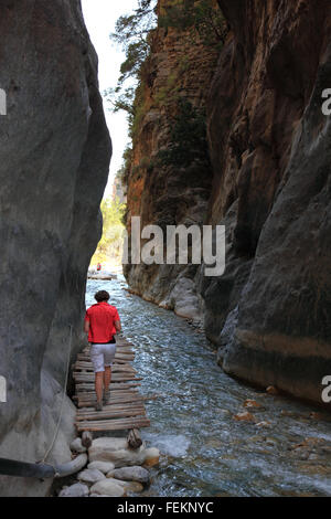 Crète, décor dans la Samarie gulch, la femme s'exécute sur une petite passerelle en bois à côté de la Brook par le ravin, la porte de fer Banque D'Images