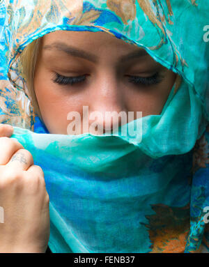 Potrait de femme portant une écharpe bleue avec les yeux fermé Banque D'Images