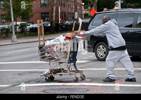 Homeless man pushing shopping trolley dans les rues de la ville de New York Banque D'Images