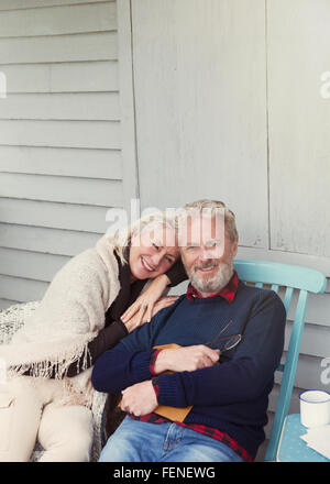 Portrait of smiling senior couple hugging on patio Banque D'Images