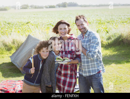 Portrait smiling family avec des hamburgers au barbecue de camping Banque D'Images