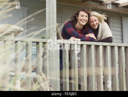 Portrait of smiling mother and daughter on porch Banque D'Images