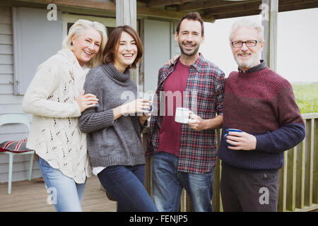 Portrait of smiling couples drinking coffee on porch Banque D'Images