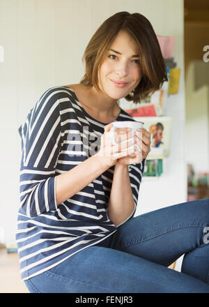 Portrait of smiling brunette woman drinking coffee Banque D'Images