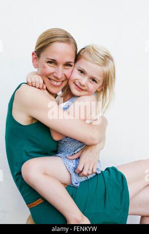Portrait of mid adult woman sitting on tour en face de mur blanc Banque D'Images
