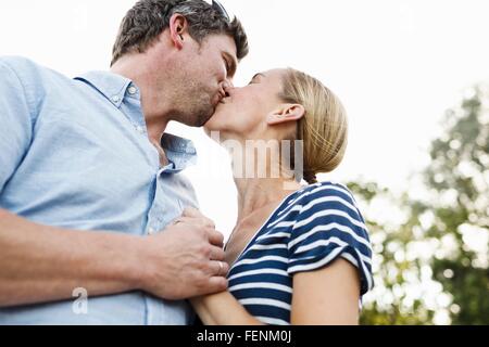Romantic couple kissing in park Banque D'Images