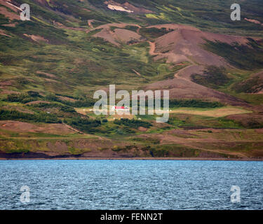 Le nord de l'Islande, Islande. 1er août 2015. La ferme se trouve sur les pentes de la montagnes plongeant dans les eaux de la généralité (EyjafjÃ rÃ°ur, le plus long fjord de nord de l'Islande. À côté de l'agriculture et de la pêche le tourisme est devenu un secteur en pleine croissance de l'économie et de l'Islande est devenue une destination touristique favorite. © Arnold Drapkin/ZUMA/Alamy Fil Live News Banque D'Images