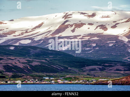 Le nord de l'Islande, Islande. 1er août 2015. Un règlement est situé sur les pentes de l'impressionnant des montagnes enneigées qui plongent dans les eaux d'¶EyjafjÃ rÃ°ur, le plus long fjord de nord de l'Islande. À côté de l'agriculture et de la pêche le tourisme est devenu un secteur en pleine croissance de l'économie et de l'Islande est devenue une destination touristique favorite. © Arnold Drapkin/ZUMA/Alamy Fil Live News Banque D'Images