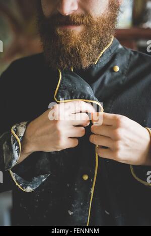 Portrait de bearded man boutonnant jusqu'argile recouverte jacket Banque D'Images