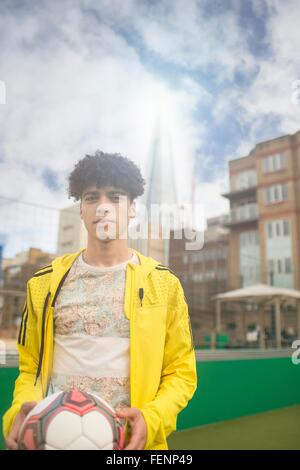 Portrait of young man holding football Banque D'Images