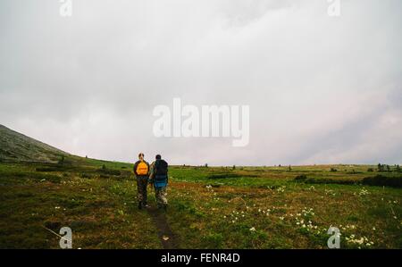 Vue arrière de l'homme et de la femme dans le paysage de la vallée de la randonnée, de l'Oural, Russie Banque D'Images