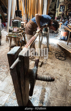 L'atelier du fabricant d'oar Paolo Brandolissio à Venise, dans le nord de l'Italie. Paolo Brandolisio remplaçant un nouveau gouvernail par une télécabine ou remo dans son travail Banque D'Images