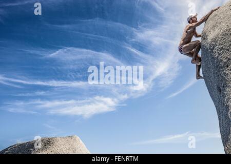 Homme portant les slips climbing rock, Villasimius, Sardaigne, Italie Banque D'Images