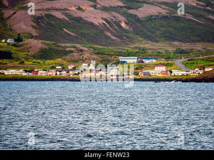 Le nord de l'Islande, Islande. 1er août 2015. Un petit village se trouve sur les pentes de la montagnes plongeant dans les eaux de la généralité (EyjafjÃ rÃ°ur, le plus long fjord de nord de l'Islande. À côté de l'agriculture et de la pêche le tourisme est devenu un secteur en pleine croissance de l'économie et de l'Islande est devenue une destination touristique favorite. © Arnold Drapkin/ZUMA/Alamy Fil Live News Banque D'Images