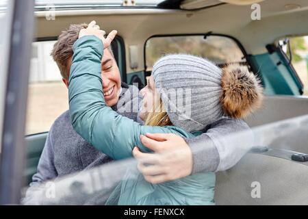 Jeune couple sur le siège avant de la voiture à la plage Banque D'Images