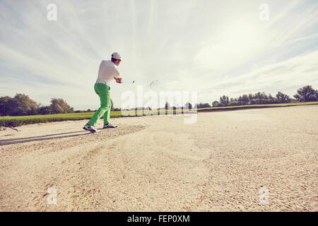 Golfer hitting ball dans la fosse de sable, Korschenbroich, Düsseldorf, Allemagne Banque D'Images