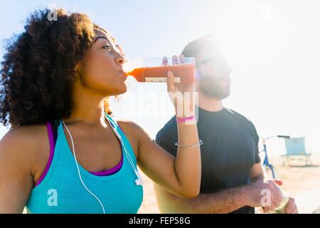 Couple sitting outdoors, boire du jus de fruits Banque D'Images