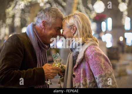 D'âge mûr de prendre une coupe de champagne sur l'avenue bordée d'arbres à Noël, Majorque, Espagne Banque D'Images