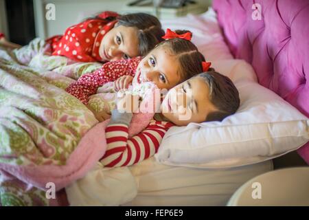 Portrait de garçon et deux sœurs Lying in Bed Banque D'Images