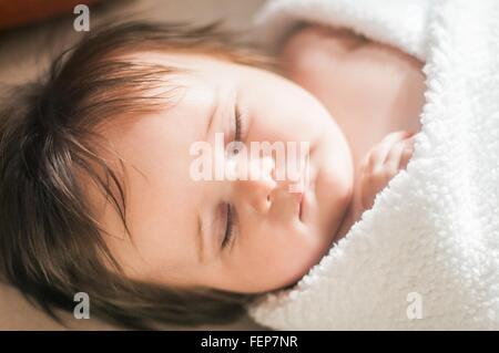 High angle view of sleeping baby girl wrapped in blanket Banque D'Images