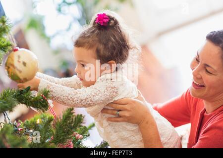 Mère et fille decorating Christmas Tree Banque D'Images