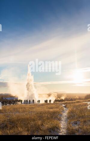 Les touristes à regarder le Grand Geyser, un geyser dans la vallée de Haukadalur sur les pentes du Laugarfjall hill, au sud-ouest de l'Islande Banque D'Images