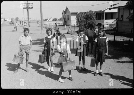 Une photographie de février 1965 à la réserve autochtone de Moree, montrant des écoliers (Stanley Binge, Heather Hammond, Jackie Cain, Julie Munro) avec un enfant inconnu. Molly French, une femme à la fenêtre, est également photographiée. L'image représente un moment important dans l'histoire des Freedom rides et de l'activisme des droits aborigènes en Australie. Banque D'Images