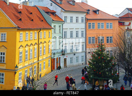 Les appartements aux couleurs vives en scène de rue à Prague à Noël avec du jaune, orange et vert et un Runner dans l'avant-plan Banque D'Images