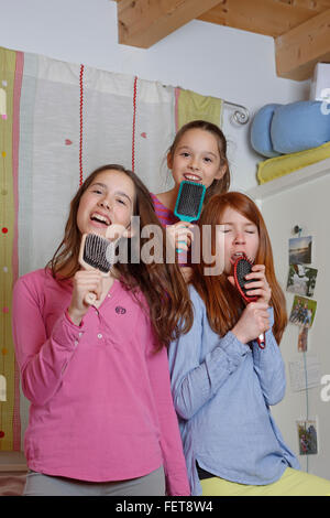 Les filles, les enfants chantent en brosse comme micro, Allemagne Banque D'Images