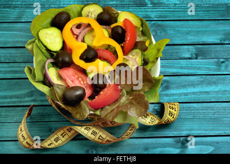 Salade de légumes avec centimètre sur table en bois bleu Banque D'Images