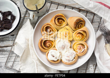 Délicieux rouleaux de pâte feuilletée (swirl) avec remplissage sucré garni de glaçage au fromage à la crème Banque D'Images