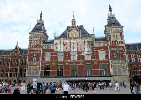 Les gens qui marchent en face de la Gare Centrale d'Amsterdam CS, comme vu de la Stationsplein (place de la gare) Banque D'Images