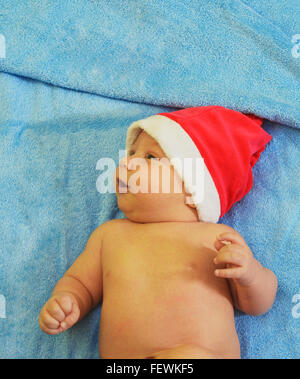 Portrait d'un bébé nouveau-né garçon avec Santa's hat in bed Banque D'Images