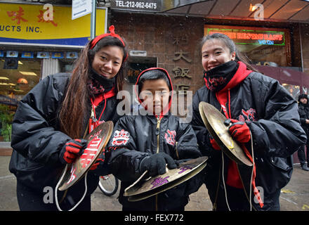 Jeune garçon chinois et de jeunes filles, jouant des cymbales dans la Nouvelle Année lunaire chinoise parade sur Mott Street dans le quartier chinois, la ville de New York. Banque D'Images