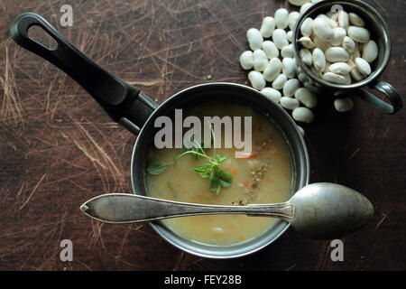 Vue d'angle sur la soupe de haricots dans une petite casserole avec une cuillère Banque D'Images