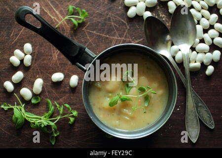 Vue d'angle sur un pot avec soupe aux haricots avec des herbes Banque D'Images